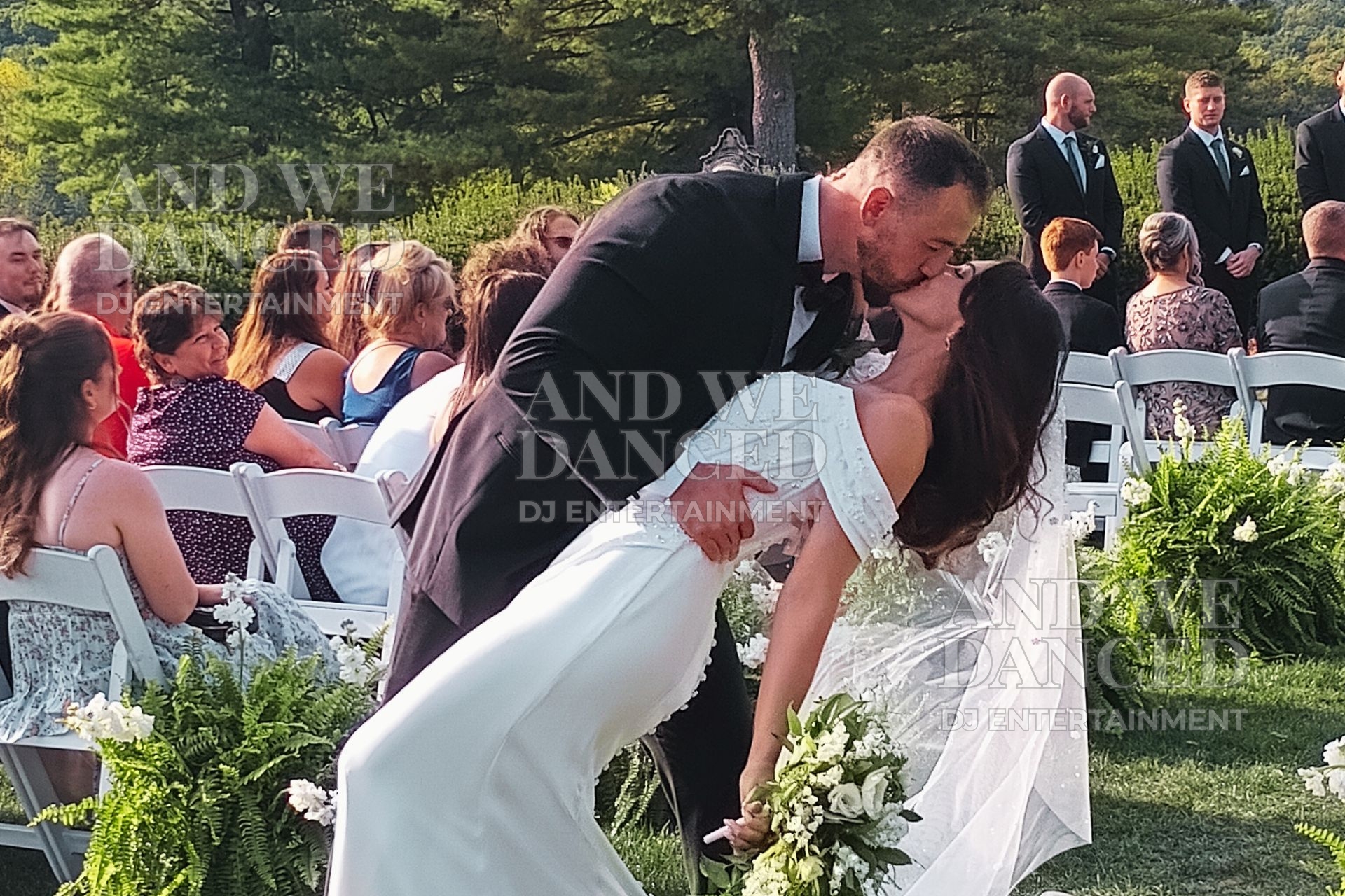 Bride and groom sharing a kiss at their outdoor wedding ceremony