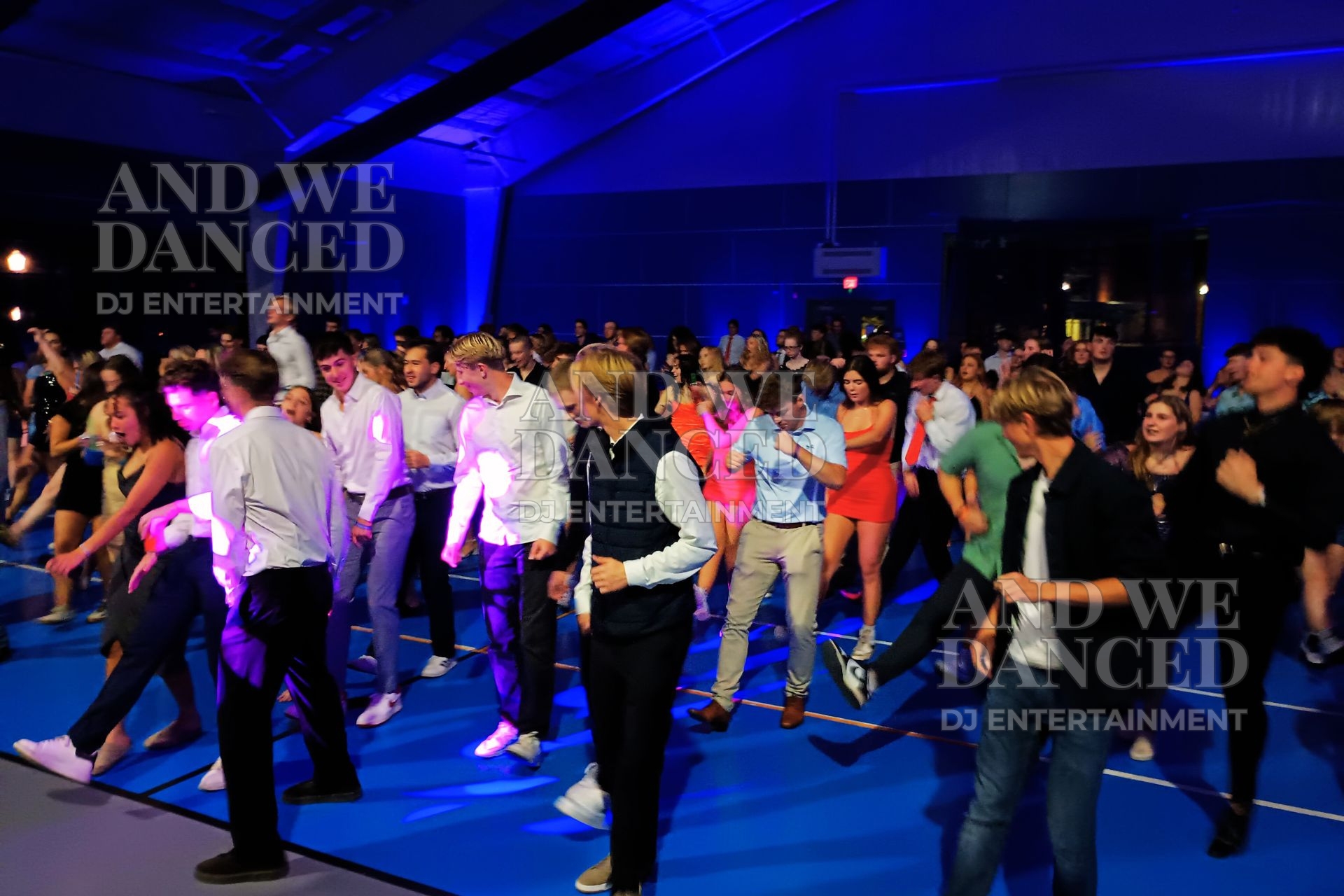 Students dancing at a school homecoming event with party lighting